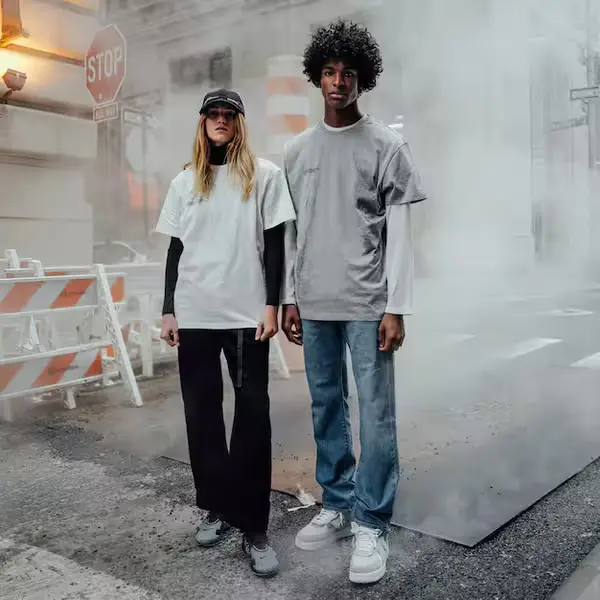 male and female standing on the road for photo shot male black male wearing grey t shirt and blue denim female wearing white t shirt and black joggers